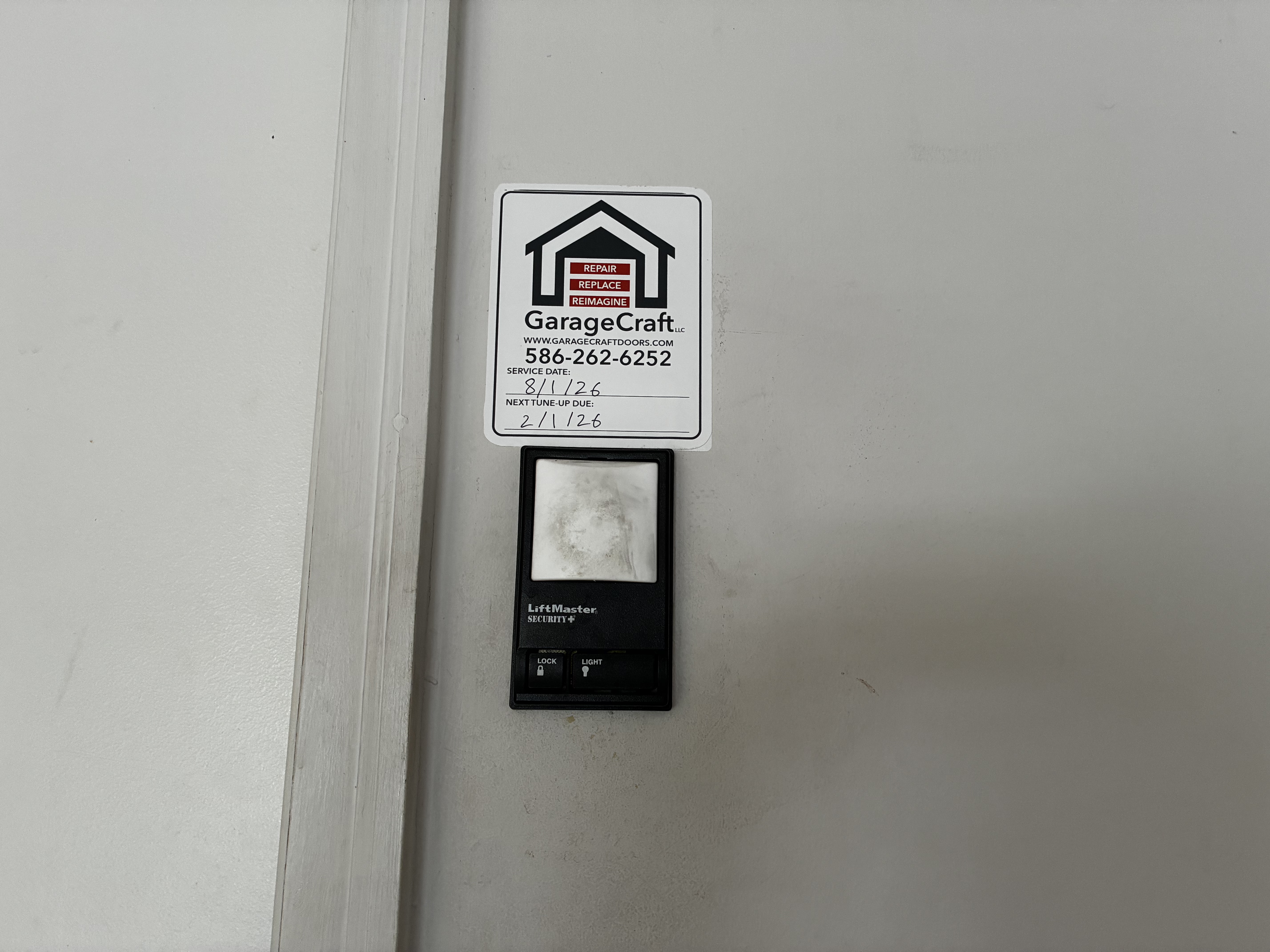 Technician performing a tune up on garage door components before hinge replacement